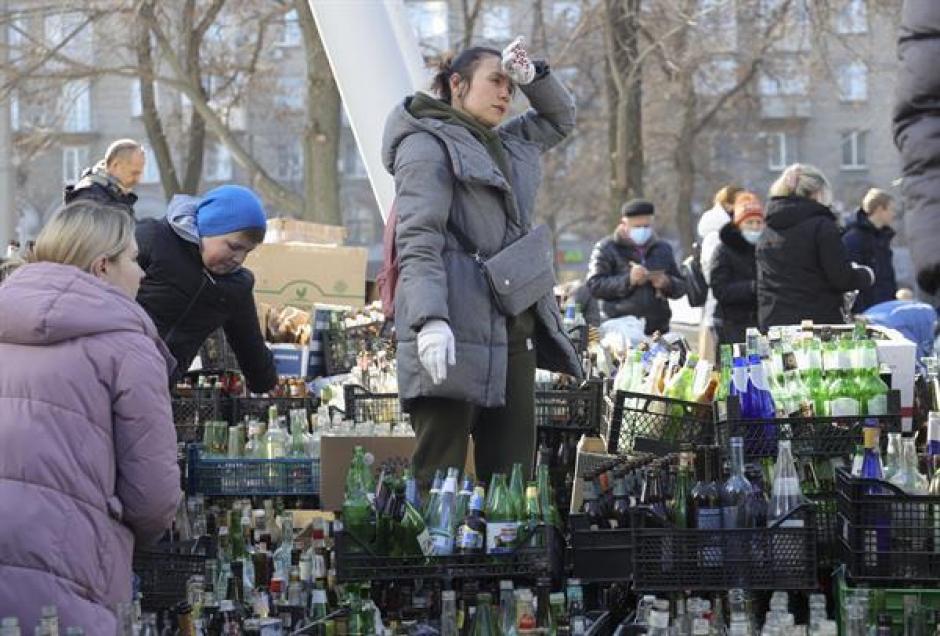 Una mujer ayuda en la recolección de botellas de vidrio para convertirlas en cócteles molotov con los que defenderse de las tropas rusas en Dnipro