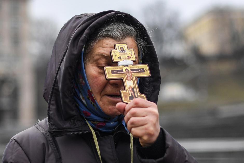 Una mujer en ucrania, portando un Cristo crucificado, en la plaza de Kiev al comienzo de la guerra
