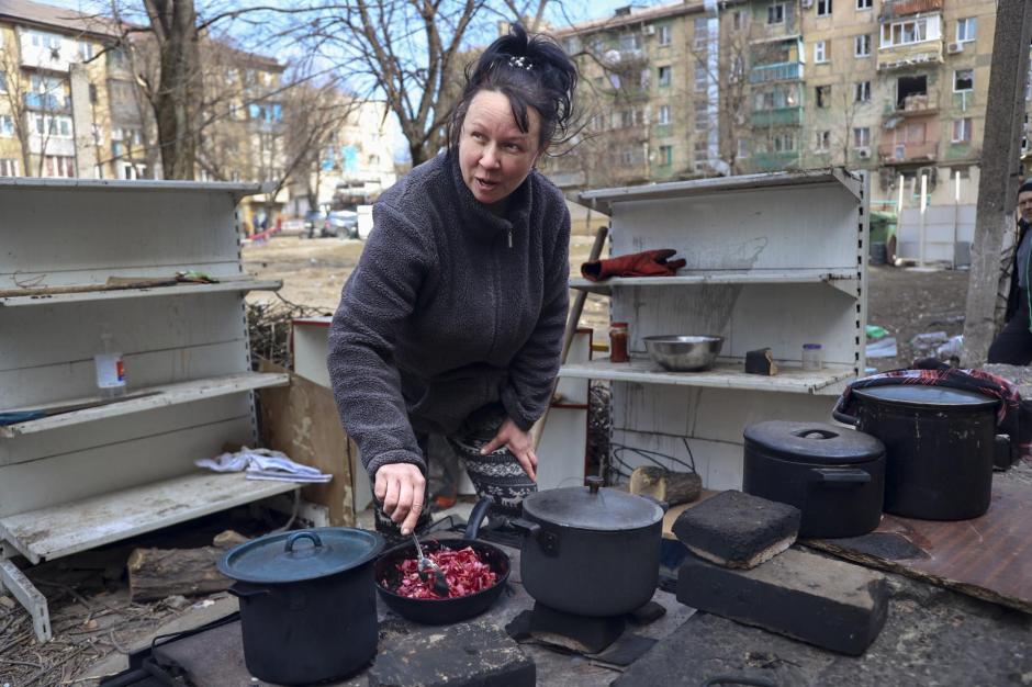Una mujer cocina en las calles de Mariúpol, durante la invasión rusa