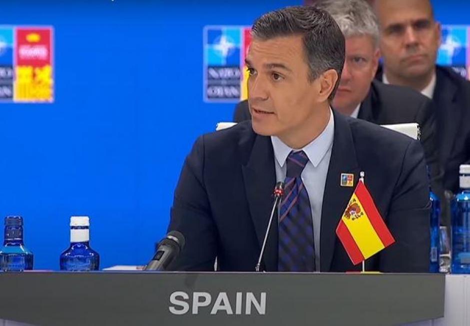Sánchez interviene desde su mesa, con la bandera de España invertida