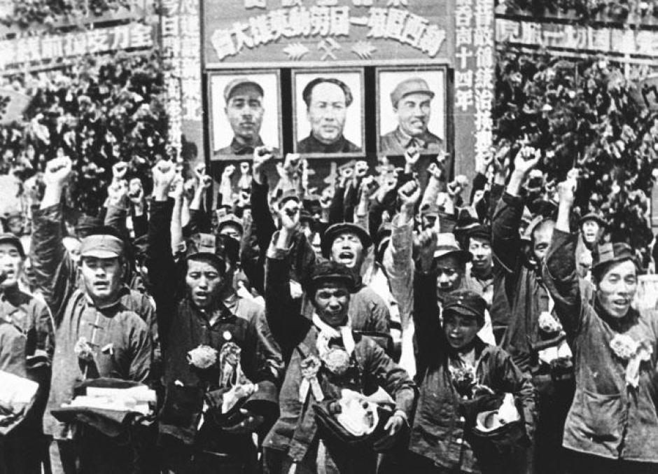 Los habitantes de la ciudad de Peiping levantan sus puños cerrados en un saludo de bienvenida a las fuerzas comunistas chinas que entran en la ciudad tras expulsar a las fuerzas nacionalistas, el 5 de febrero de 1949.  El retrato central detrás de ellos es del General Mao Zedong.