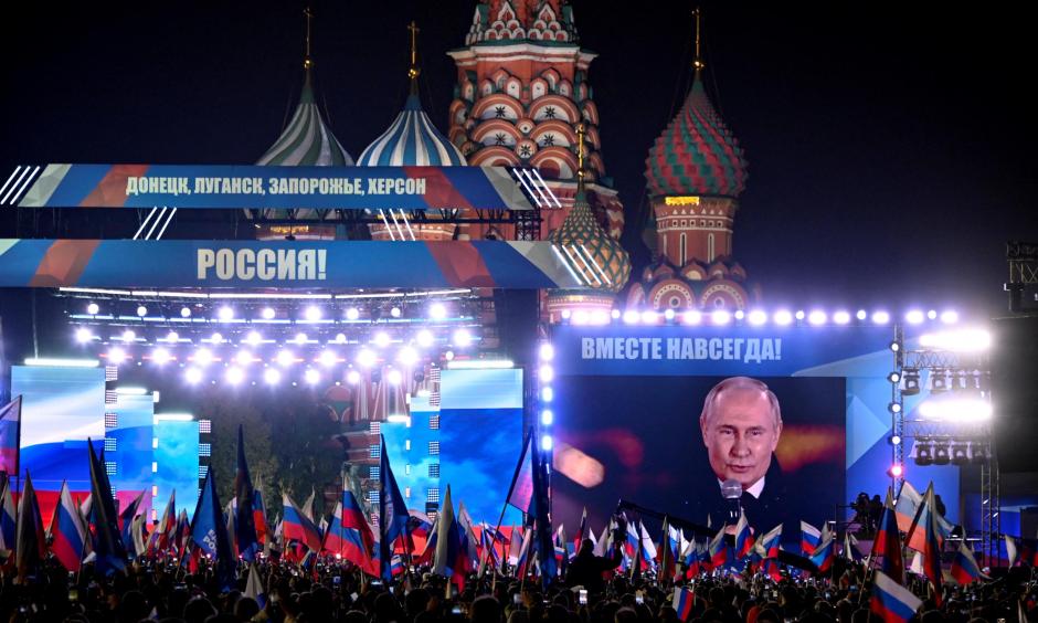 Vladimir Putin se ve en una pantalla en la Plaza Roja de Moscú durante un discurso previo a un concierto