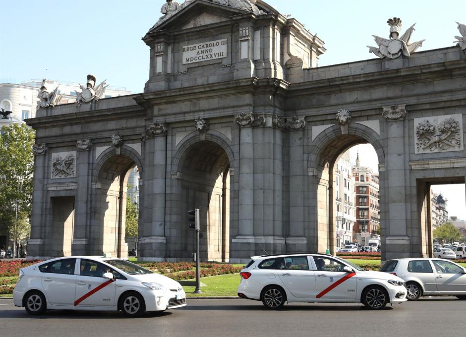 Imagen de recurso de varios taxis a su paso por la Puerta de Alcalá, en la ciudad de Madrid