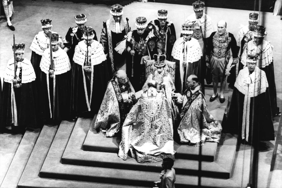 La reina Isabel II de Gran Bretaña, sentada en el trono, recibe la lealtad del arzobispo de Canterbury, en el centro de espaldas a la cámara, el obispo de Durham, a la izquierda y el obispo de Bath y Wells, durante su coronación en la Abadía de Westminster