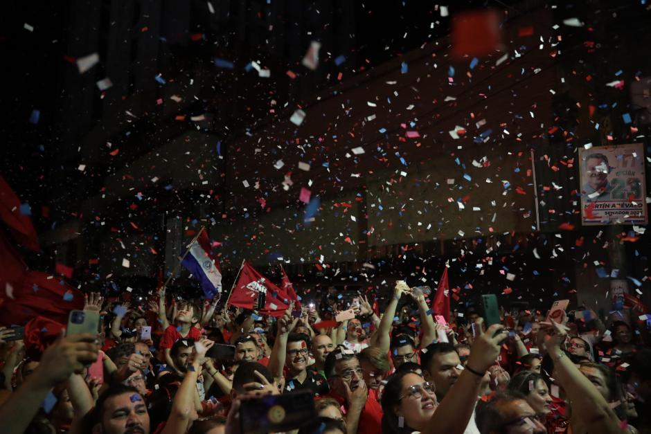 AME5727. ASUNCIÓN (PARAGUAY), 30/04/2023.- Seguidores del presidente electo del Partido Colorado, Santiago Peña, celebran tras su victoria a las afueras de su sede campaña, hoy en Asunción (Paraguay). El candidato se proclamó ganador de las elecciones presidenciales celebradas este domingo en Paraguay, en una jornada en la que el oficialismo conquistó además la mayoría en el Senado y se impuso en al menos 14 de las 17 gobernaciones en disputa, según el conteo provisional oficial. EFE/ Raúl Martínez