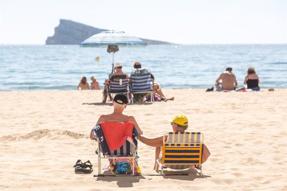 Numerosas personas se bañan y toman el sol en la playa de Poniente, Benidorm, Alicante