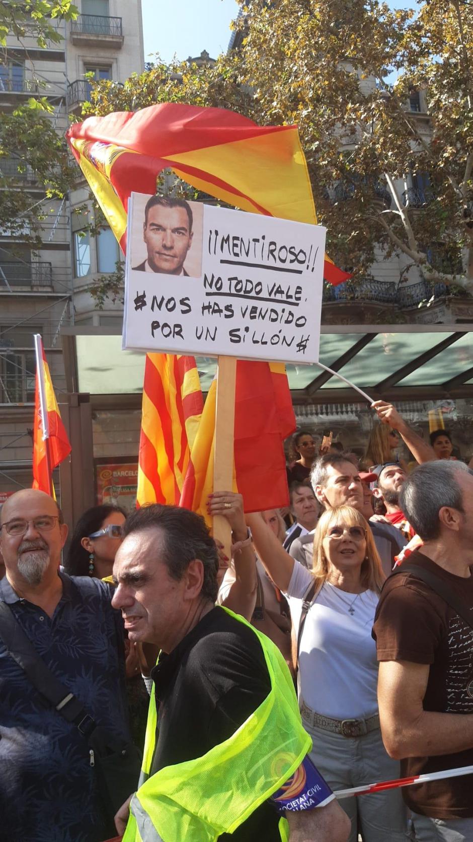 Una manifestante portando una pancarta contra el presidente del Gobierno