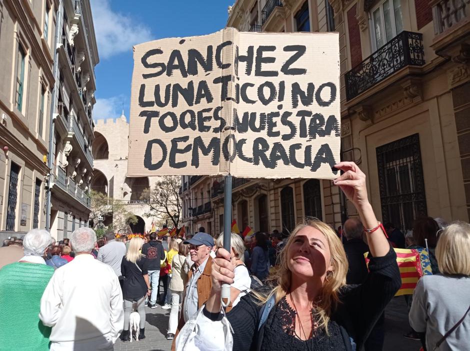Una mujer porta un cartel contra las pretensiones de Sánchez