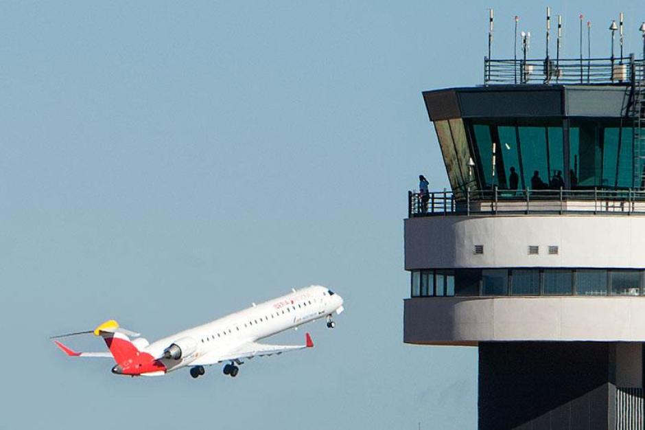 Torre de control del Aeropuerto de Castellón, con un avión de fondo
