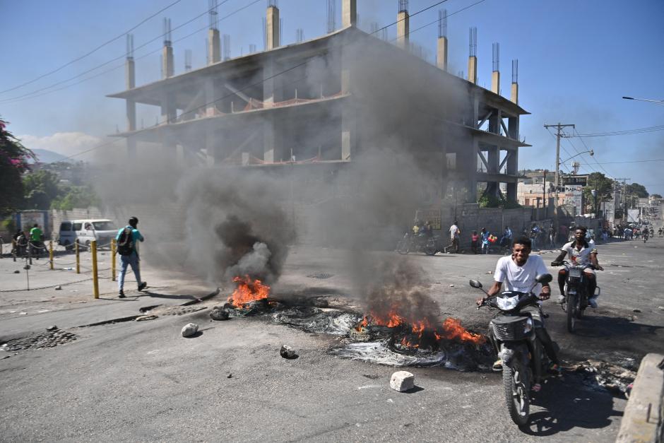 Un motoclicista pasa junto a una barricada en llamas en Puerto Príncipe, a 18 de enero