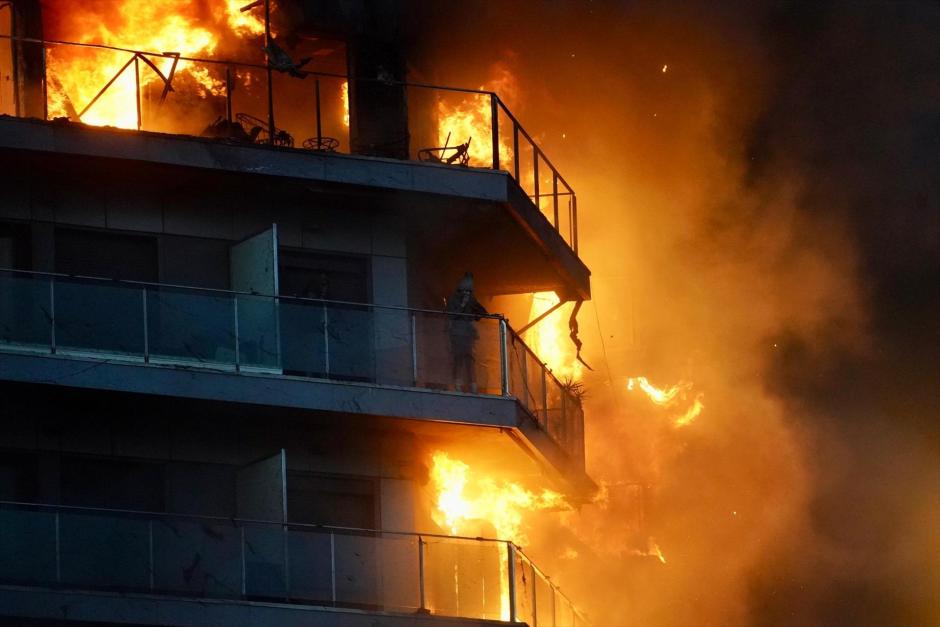 Una persona en un balcón del edificio en llamas, en el barrio de Campanar, en Valencia