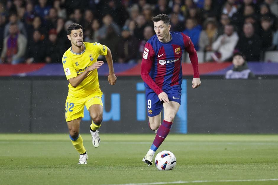 El delantero del FC Barcelona Robert Lewandowski (d) se escapa del francés Enzo Loiodice, de la UD Las Palmas