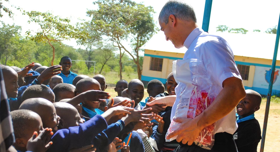 Un sacerdote reparte caramelos entre los alumnos de un colegio católico en África