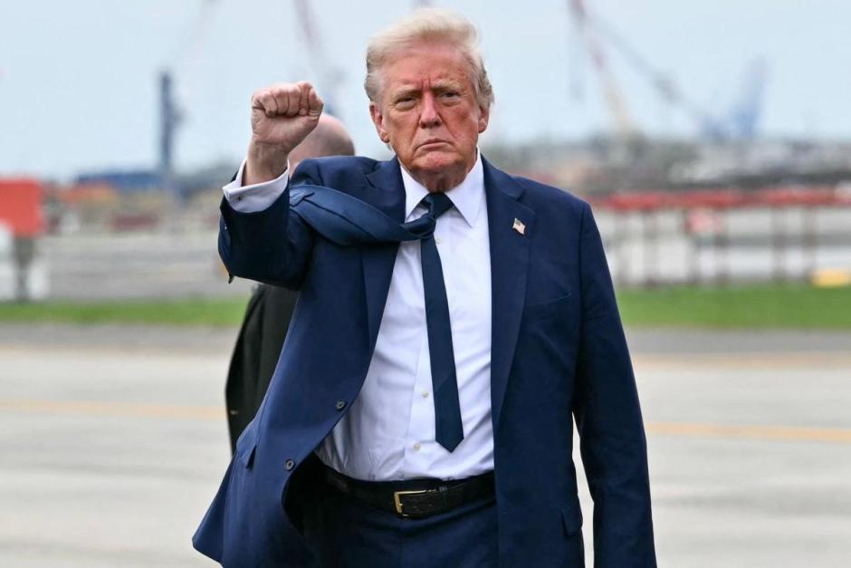 El presidente de Estados Unidos, Donald Trump, levanta el puño al descender del avión de la Fuerza Aérea
