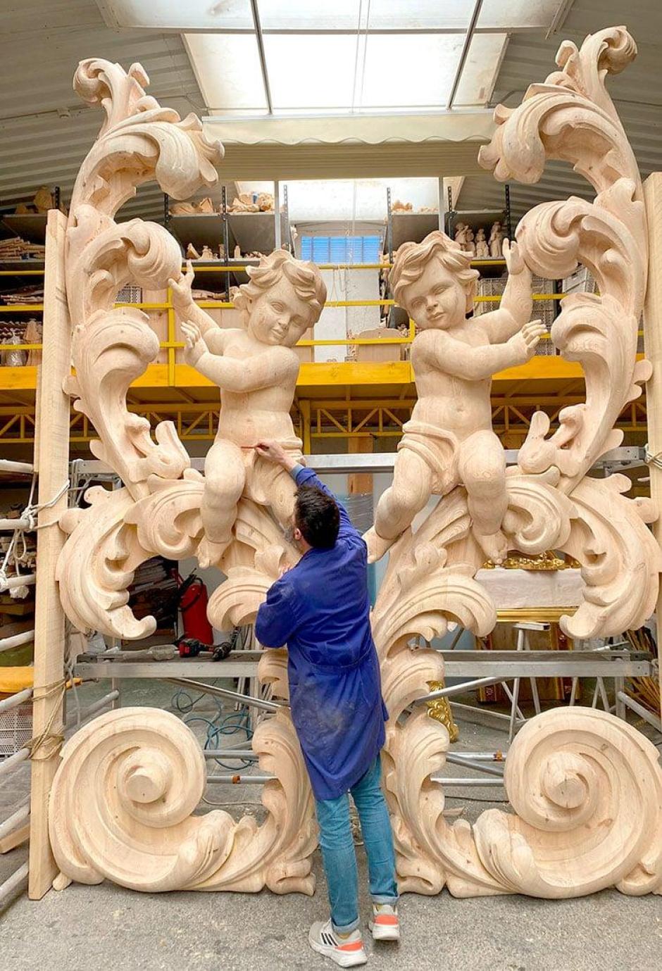 Un operario da los últimos retoques a las piezas que coronan el retablo de Chelva