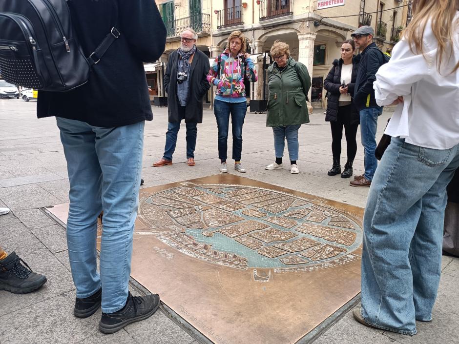 Un grupo internacional de periodistas contempla una placa con el plano de Aranda de Duero