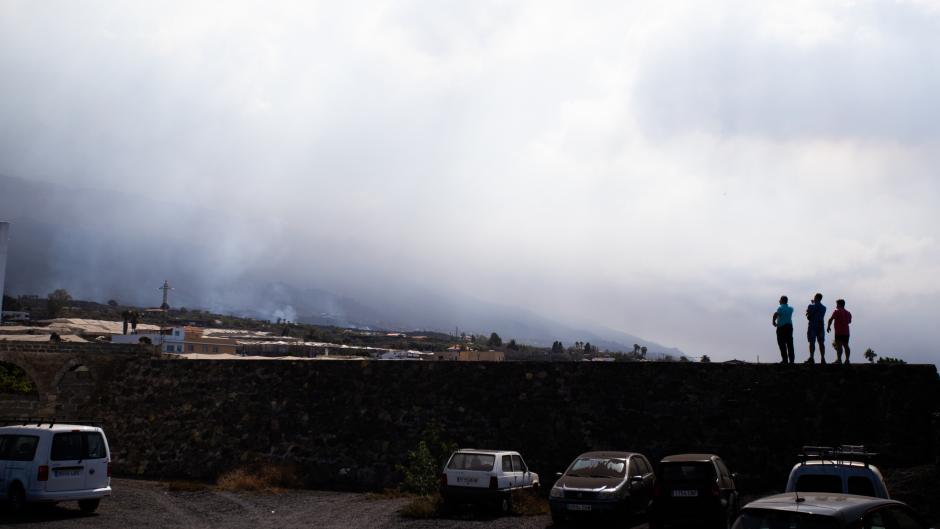 Varios vecinos observan el paso de las coladas de lava por la parte industrial de La Laguna