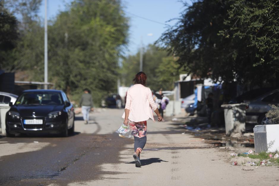 Una mujer caminando dirección a la salida del Sector 6 de la Cañada Real