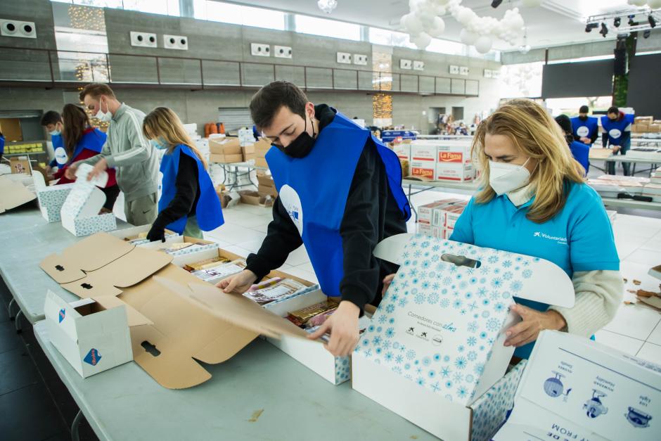 Voluntarios de Cesal preparan las cajas de comida que repartirán en Navidad