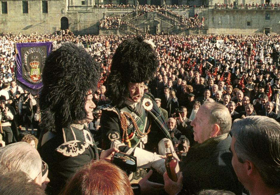 Manuel Fraga recibe una botella de whisky de un grupo de gaiteiros escoceses, durante los actos de su toma de posesión en la Plaza del Obradoiro, ante cerca de 6000 gaiteiros