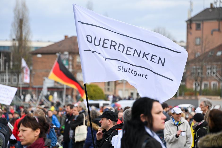 Un manifestante sostiene una bandera de Querdenken