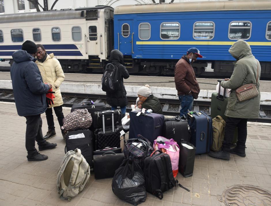 Un grupo de personas espera con sus maletas en una estación de tren para viajar fuera de Kiev