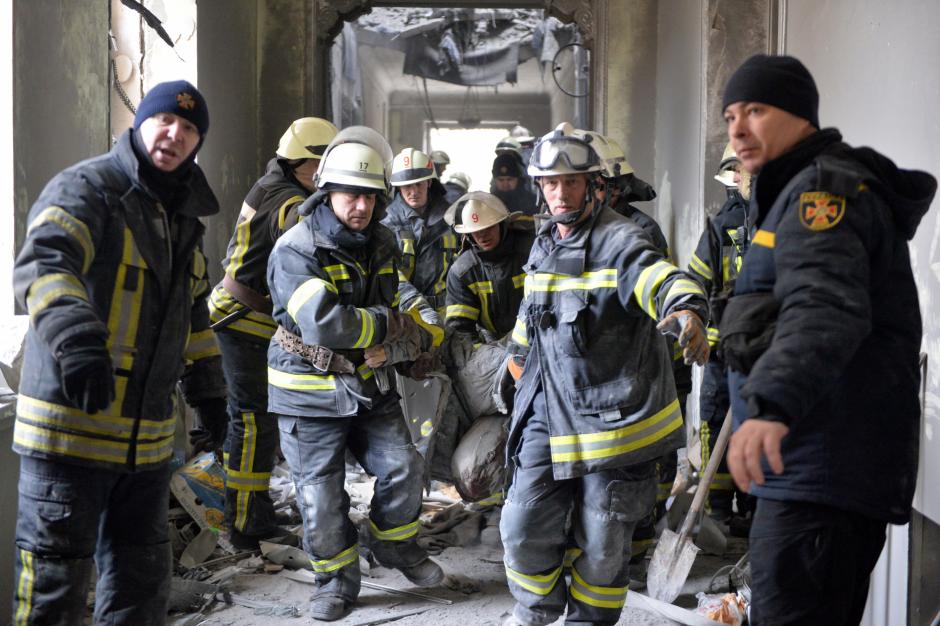 Un grupo de bomberos evacúa a un herido de un edificio de Járkov tras un bombardeo ruso