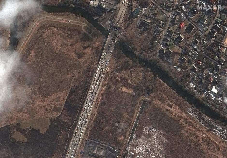 Los bombardeos contra infraestructuras afectan a las rutas de evacuación de los civiles. En la imagen puede verse una caravana de coches detenido ante un puente destruido en Irpin.
