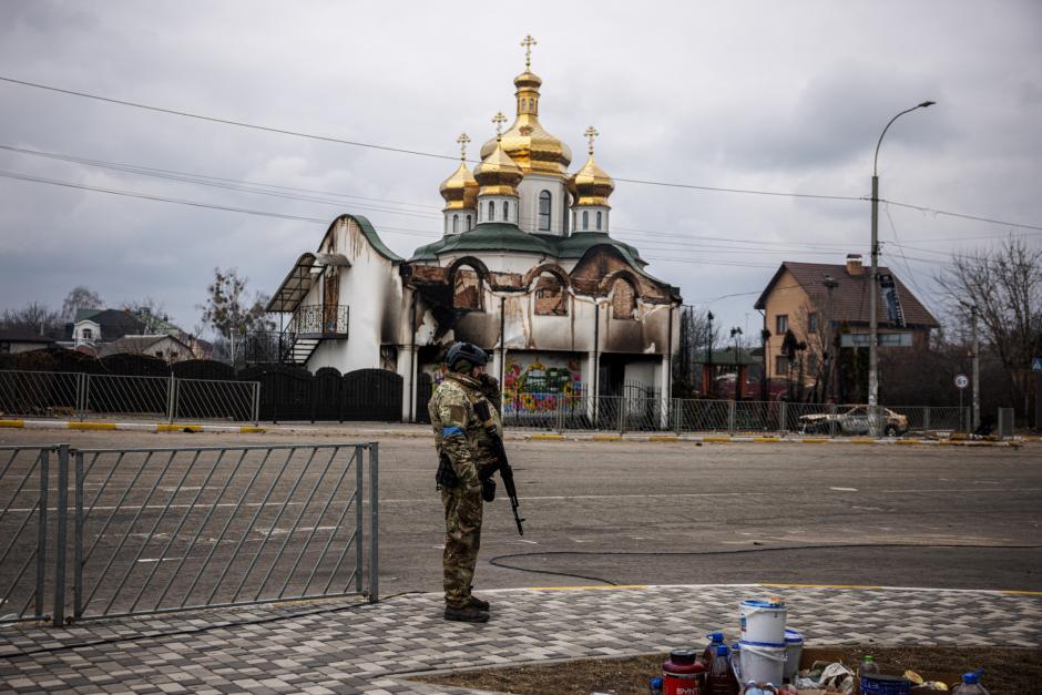 Un militar ucraniano frente a una iglesia destruida en Irpin