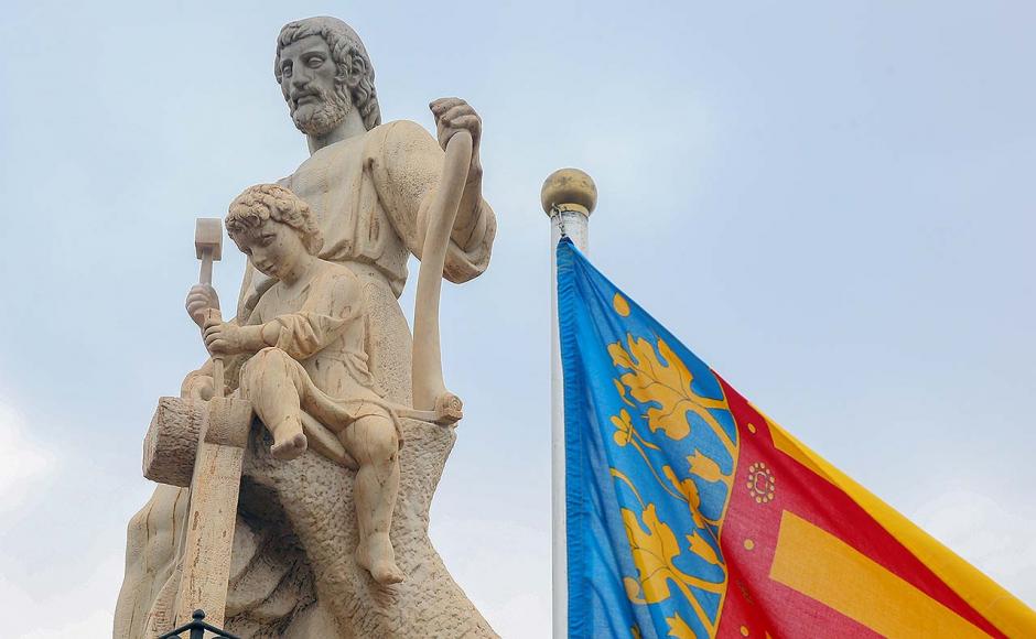 Imagen de san José enseñando al niño carpintería junto a la bandera de la Comunidad Valenciana