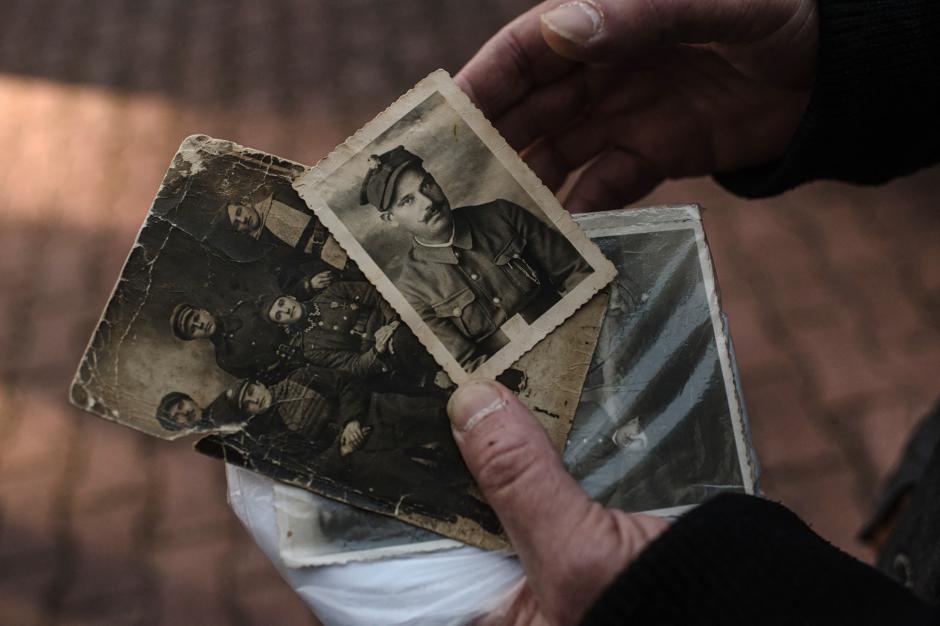 El bielorruso Andrei Korsak muestra fotografías antiguas de su abuelo durante la Segunda Guerra Mundial que planea llevar a Ucrania