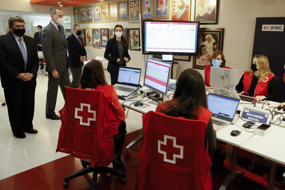 Los reyes Felipe VI y Letizia, acompañados por el ministro de Inclusión, Seguridad Social y Migraciones, José Luis Escrivá (i), visitan la célula de crisis sobre Ucrania de Cruz Roja, este miércoles, en Madrid. E