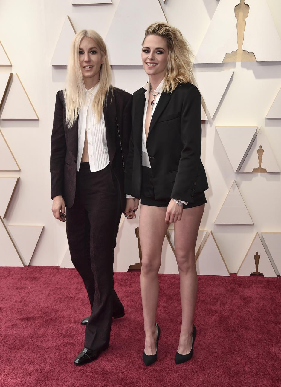 Dylan Meyer y Kristen Stewart en la alfombra roja de los Oscar 2022, saltándose el protocolo de vestimenta de la gala, que dictamina que las mujeres deben ir con vestido largo
