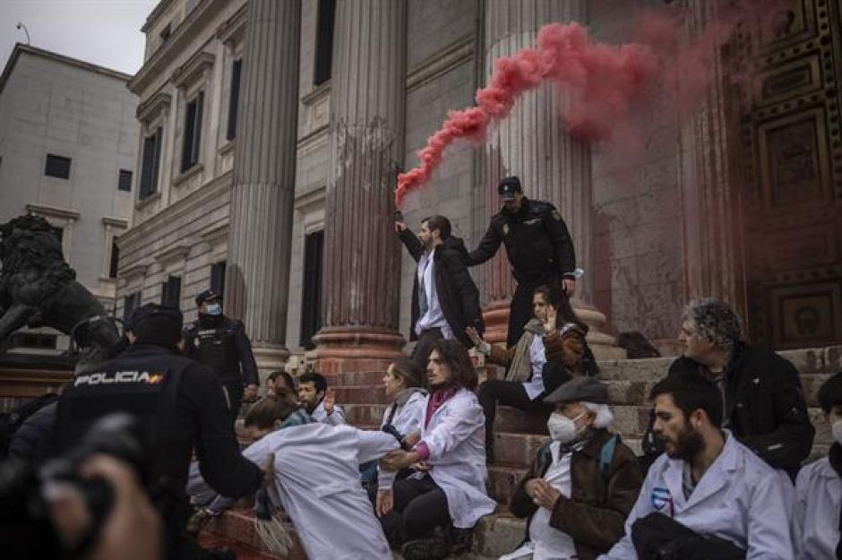 Radicales del grupo Scientist Rebellion protagonizan una sentada ante la Puerta de los Leones tras arrojar pintura contra la fachada del Congreso de los Diputados