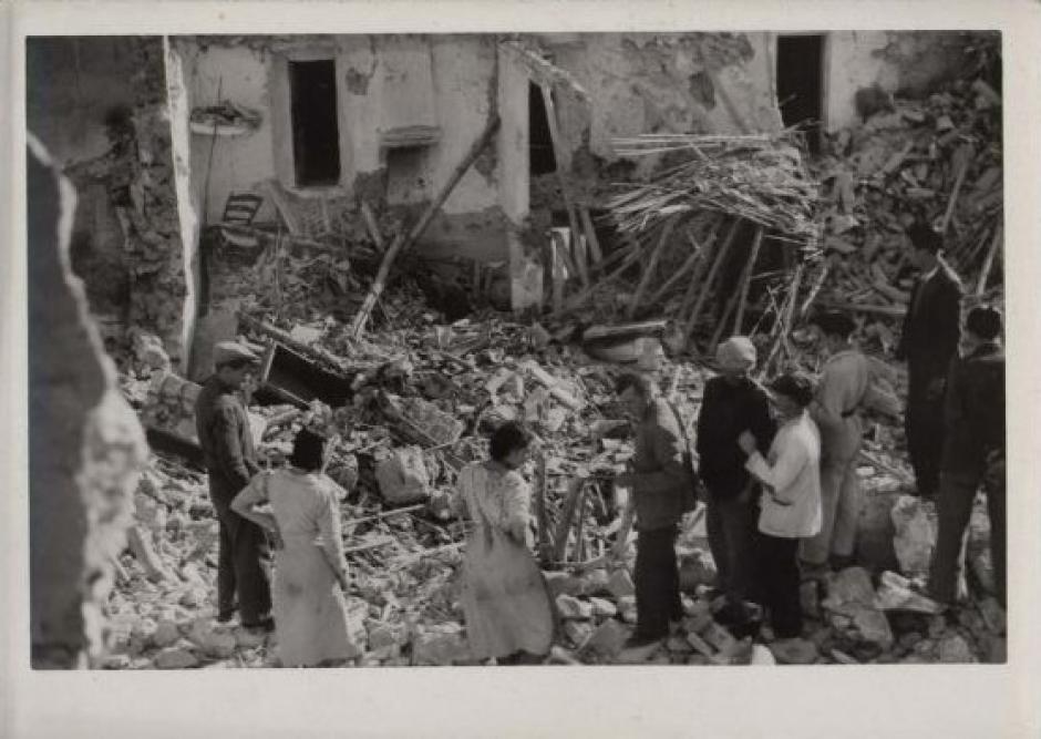 Un grupo de vecinos obreros viendo sus casas destruidas en el barrio de la Villa