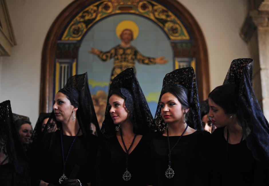 Women wearing the traditional mantilla from "Jesus Caido" brotherhood participate during a Holy Week procession in Cordoba, Spain, Thursday, April 2, 2015.