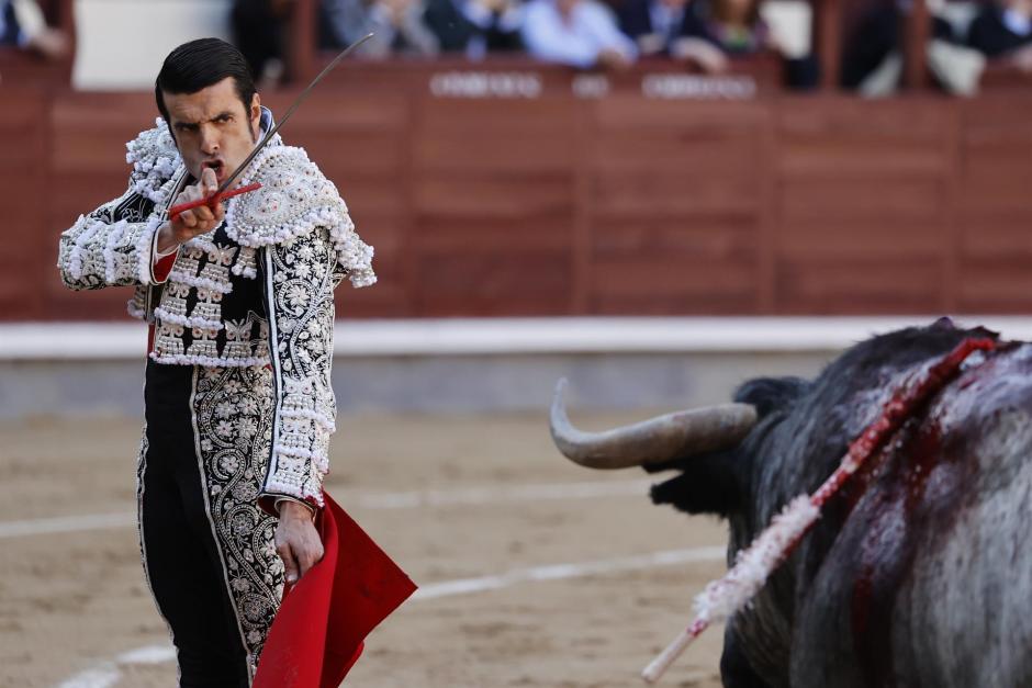 El diestro Emilio de Justo se dispone a entrar a matar antes de ser cogido por el toro durante la corrida del Domingo de Ramos, en el coso taurino de Las Ventas