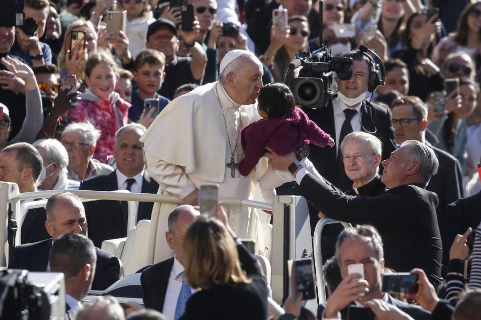 El Papa Francisco besando a un bebé, a su llegada a la audiencia