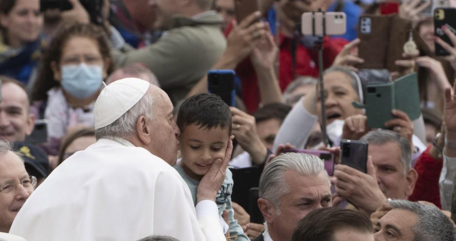 El Pontífice, besando a un niño en su recorrido por la plaza de San Pedro al comienzo de la audiencia general de los miércoles
