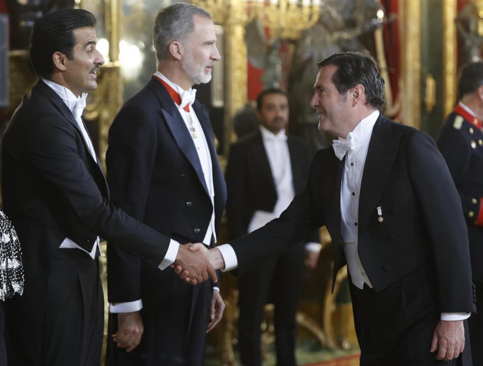 El emir de Qatar Tamim bin Hamad Al Thani (i) saluda al presidente de la CEOE Antonio Garamendi (d), acompañado por el rey Felipe VI (c), antes de la cena de gala que los monarcas españoles ofrecen al mandatario qatarí y a su esposa