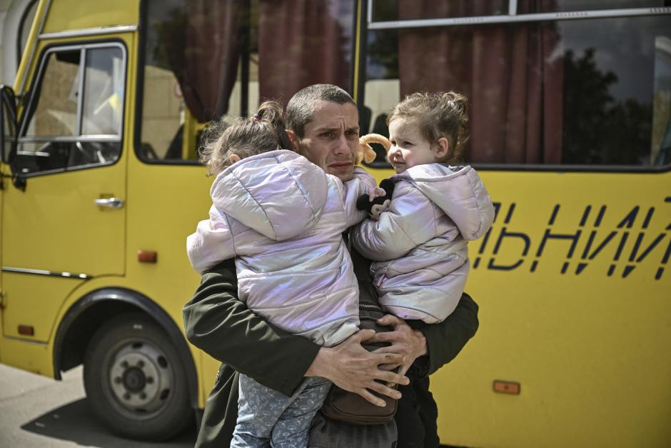 Un hombre viudo sujeta en brazos a sus dos hijas gemelas mientras espera a ser evacuado.