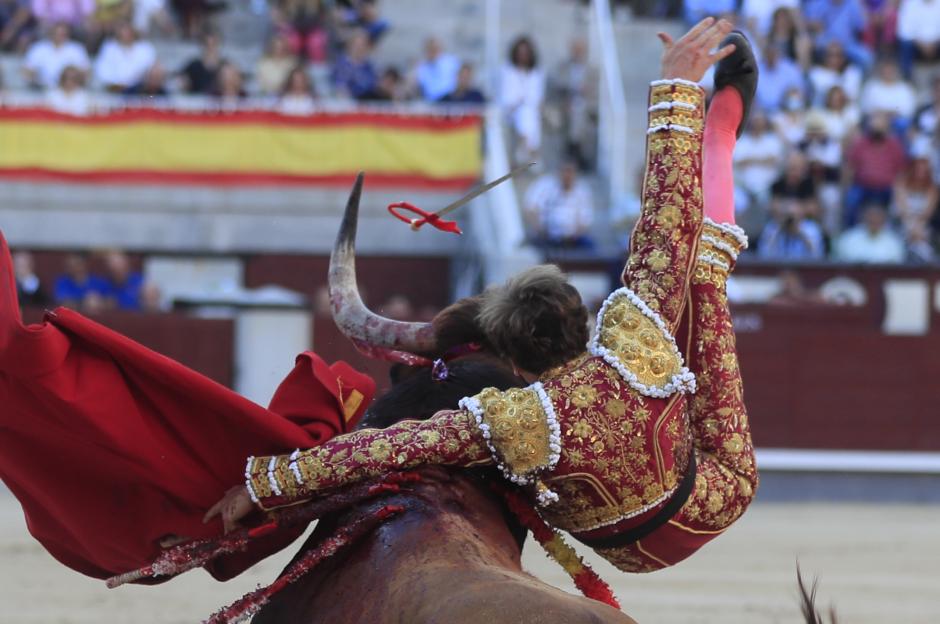 El diestro Román Collado sufre un revolcón durante su faena en la corrida de la Feria de San Isidro