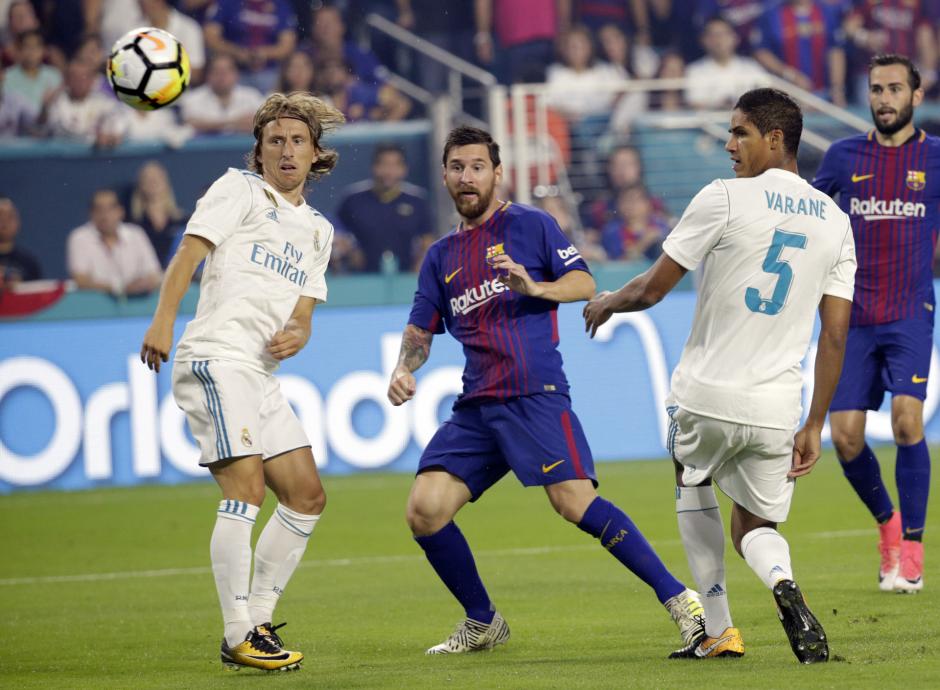 Luka Modric y Raphaël Varane defendiendo a Leo Messi en el clásico veraniego de 2017