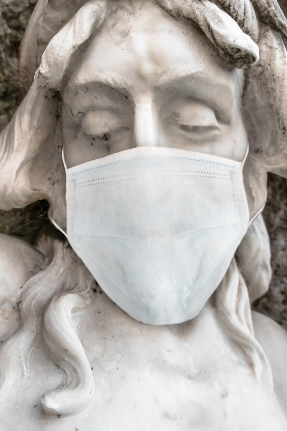 Jesus Christ statue with medical mask. COVID-19 in the world. For coronavirus epidemic concepts.