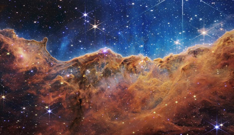 Detrás de la cortina de polvo y gas en estos "acantilados cósmicos" hay estrellas bebés previamente escondidas, ahora descubiertas por Webb