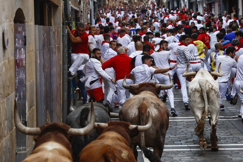 Los mozos son perseguidos por los toros de la ganadería Miura durante el octavo y último encierro de los Sanfermines este jueves en Pamplona