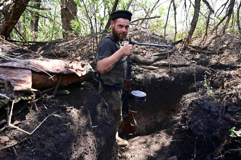 An Ukrainian soldier poses with an ukranian machine gun in a trench near the front line in eastern Ukraine, on July 13, 2022, amid the Russian invasion of Ukraine. (Photo by MIGUEL MEDINA / AFP)