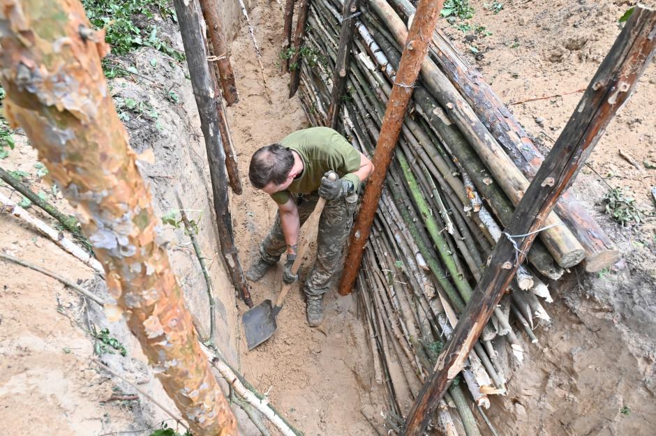 A Ukrainian serviceman digs with a shovel in a trench on a position near Kharkiv on July 5, 2022, amid the Russian invasion of Ukraine. (Photo by SERGEY BOBOK / AFP)