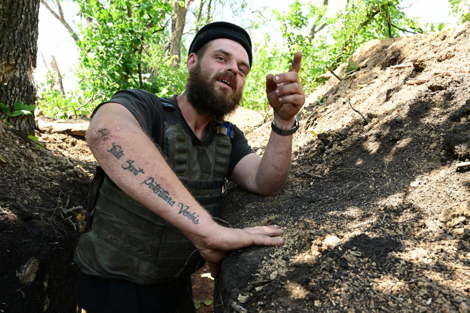 An Ukrainian soldier with nickname Grizzli with a tattoo written in Latin that says "Acts are stronger than words" is pictured in a trench near the front line in eastern Ukraine, on July 13, 2022, amid the Russian invasion of Ukraine. (Photo by MIGUEL MEDINA / AFP)