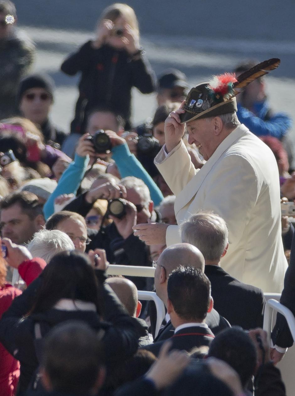 Pope Francis wears an Italian Alpine troops hat he was offered while touring St. Peter's Square at the Vatican prior to the start of his weekly general audience, Wednesday, March 5, 2014.